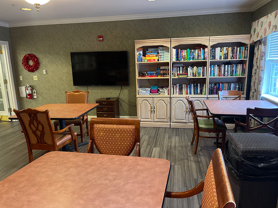 Cozy room with tables, bookshelves, and a television.