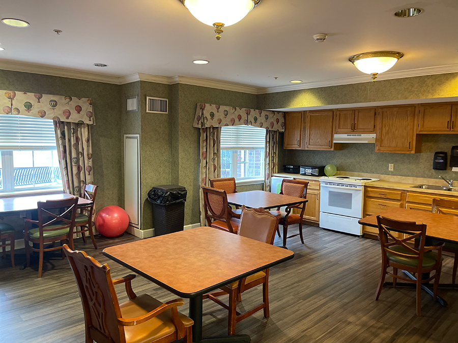 Cozy communal kitchen and dining area with tables and chairs.
