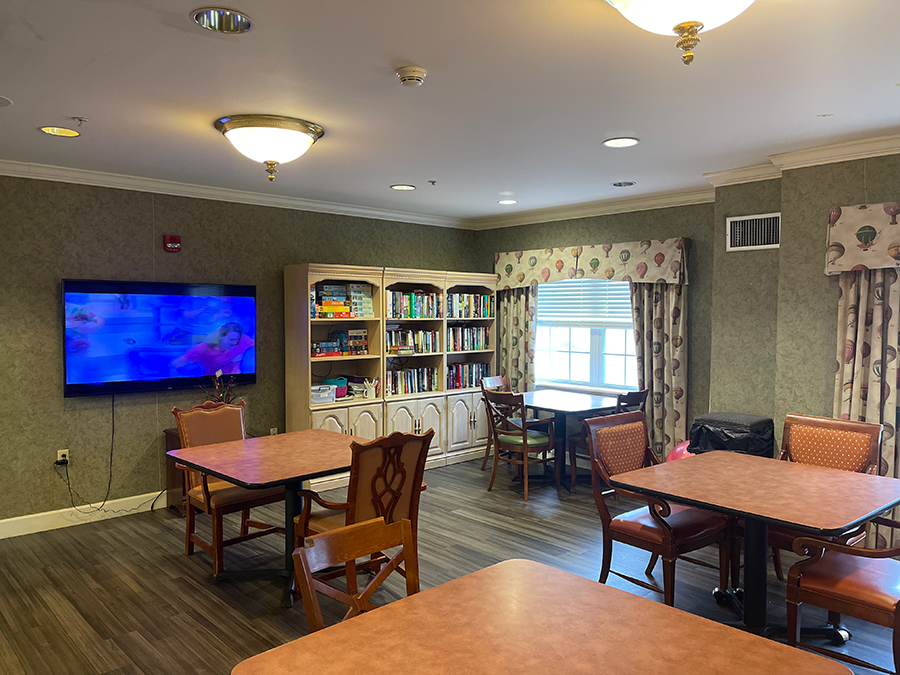 Cozy room with tables, bookshelves, and a television.