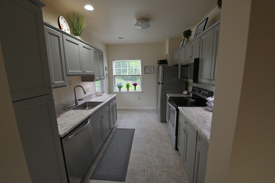 Modern kitchen with gray cabinets and natural light.