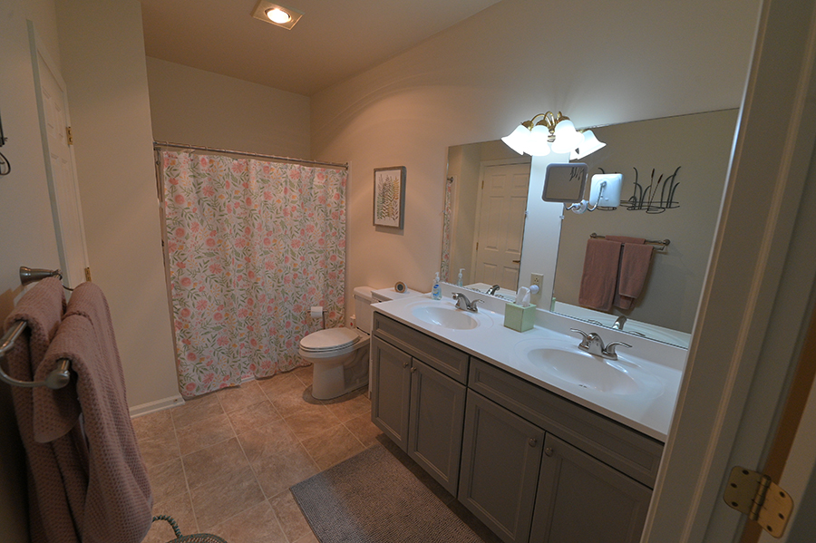 Elegant bathroom with double sinks and floral shower curtain.