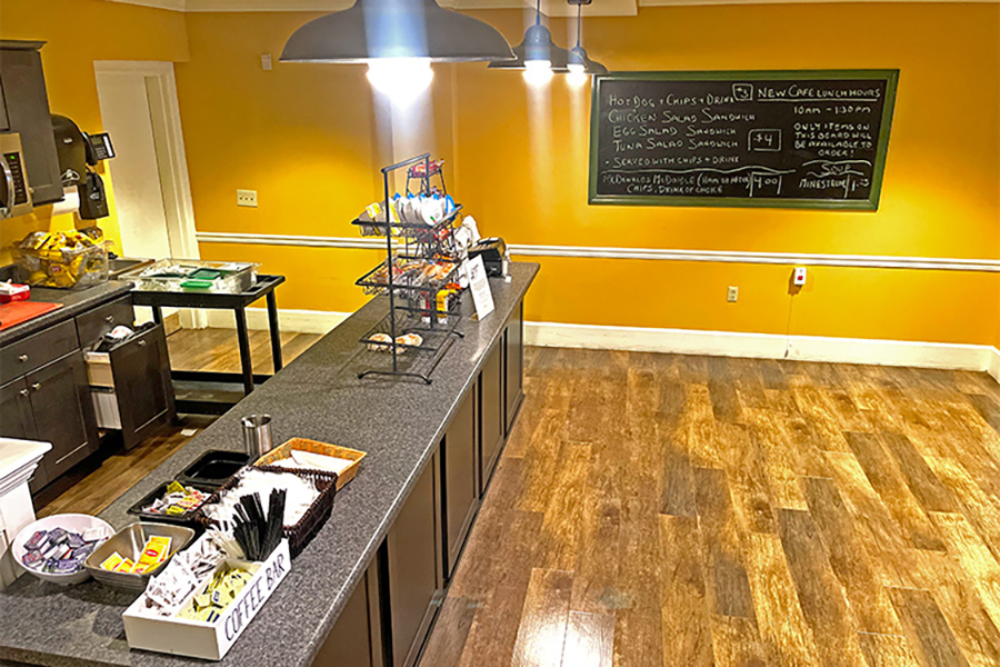 Cafeteria setting with counter, menu board, and food items.
