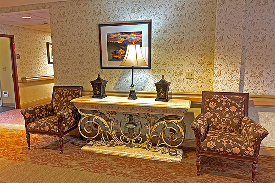 Elegant hallway with floral chairs and decorative console table.