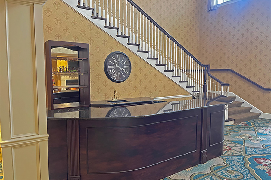 Elegant hotel lobby with stairway and reception desk.
