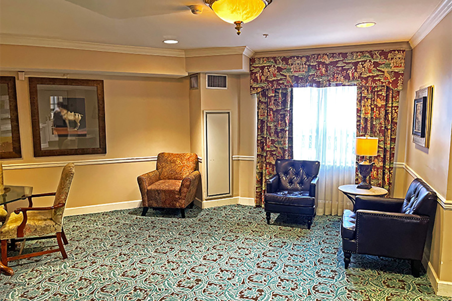 Cozy sitting area with patterned carpet and window light.