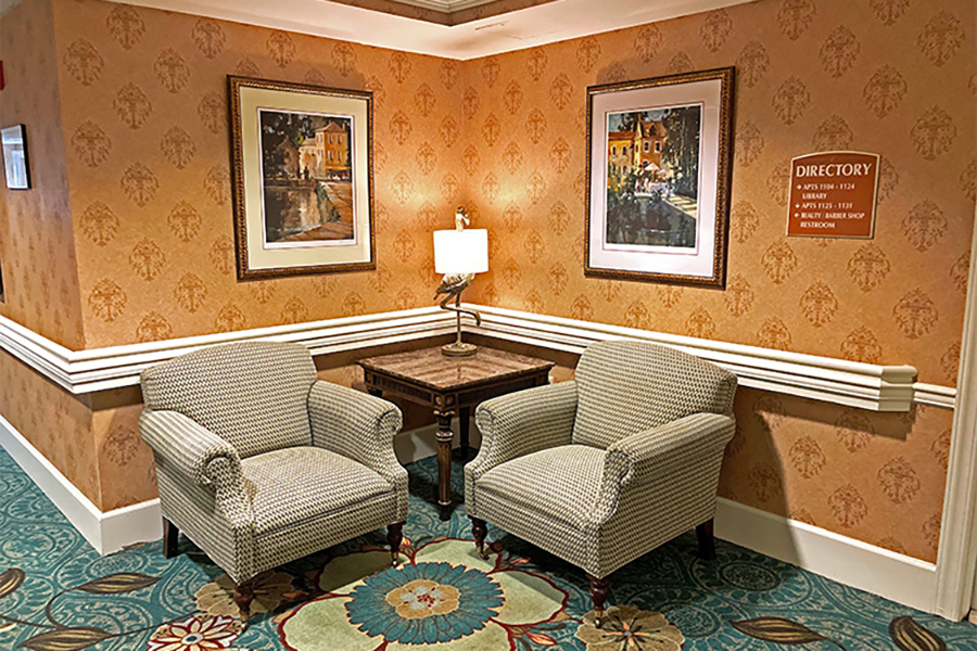 Cozy seating area with decorative wallpaper and artwork.