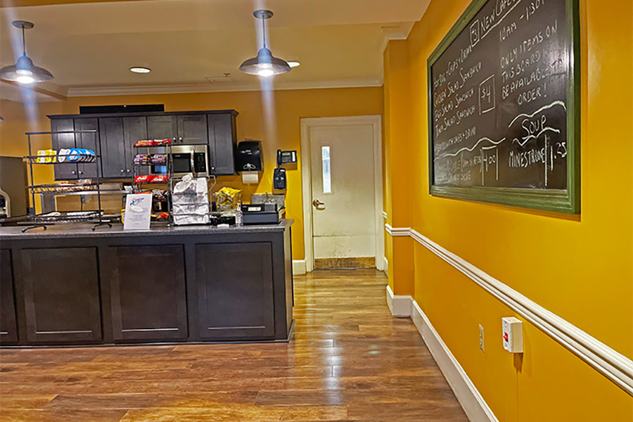 Warm, yellow cafe with a service counter and chalkboard menu.