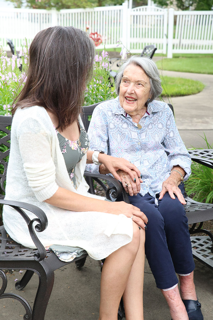Two women sharing a joyful moment on a bench.