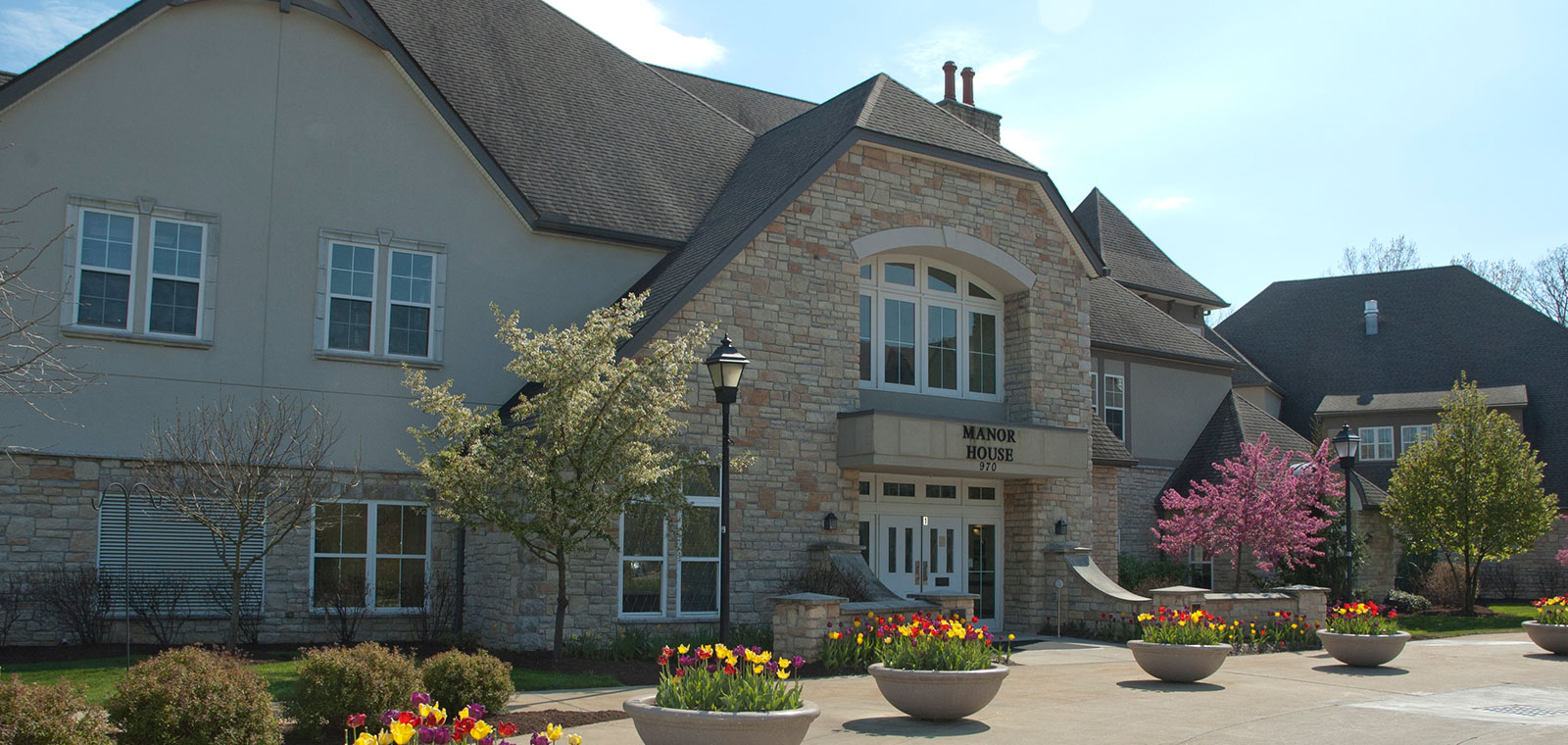 Elegant building surrounded by colorful flowers and trees.