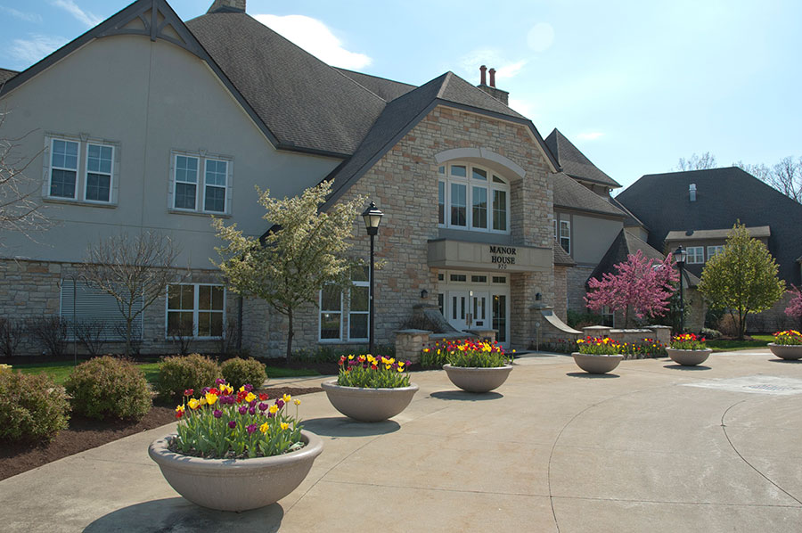 Elegant building surrounded by flowering gardens and pathways.