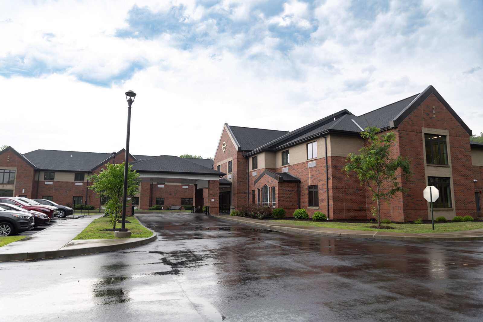 Brick buildings with a wet road and cloudy sky.
