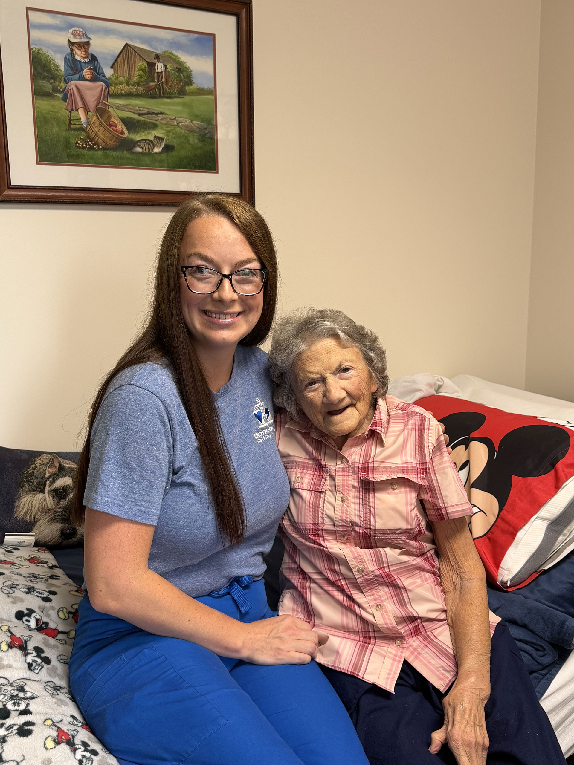 Two women smiling together in a cozy room.