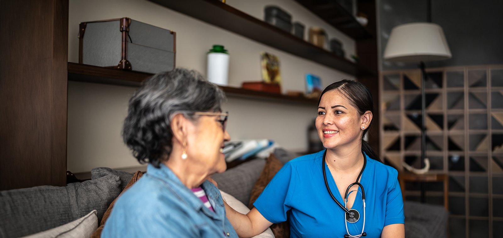 Young nurse woman talking with senior patient woman at nursing home