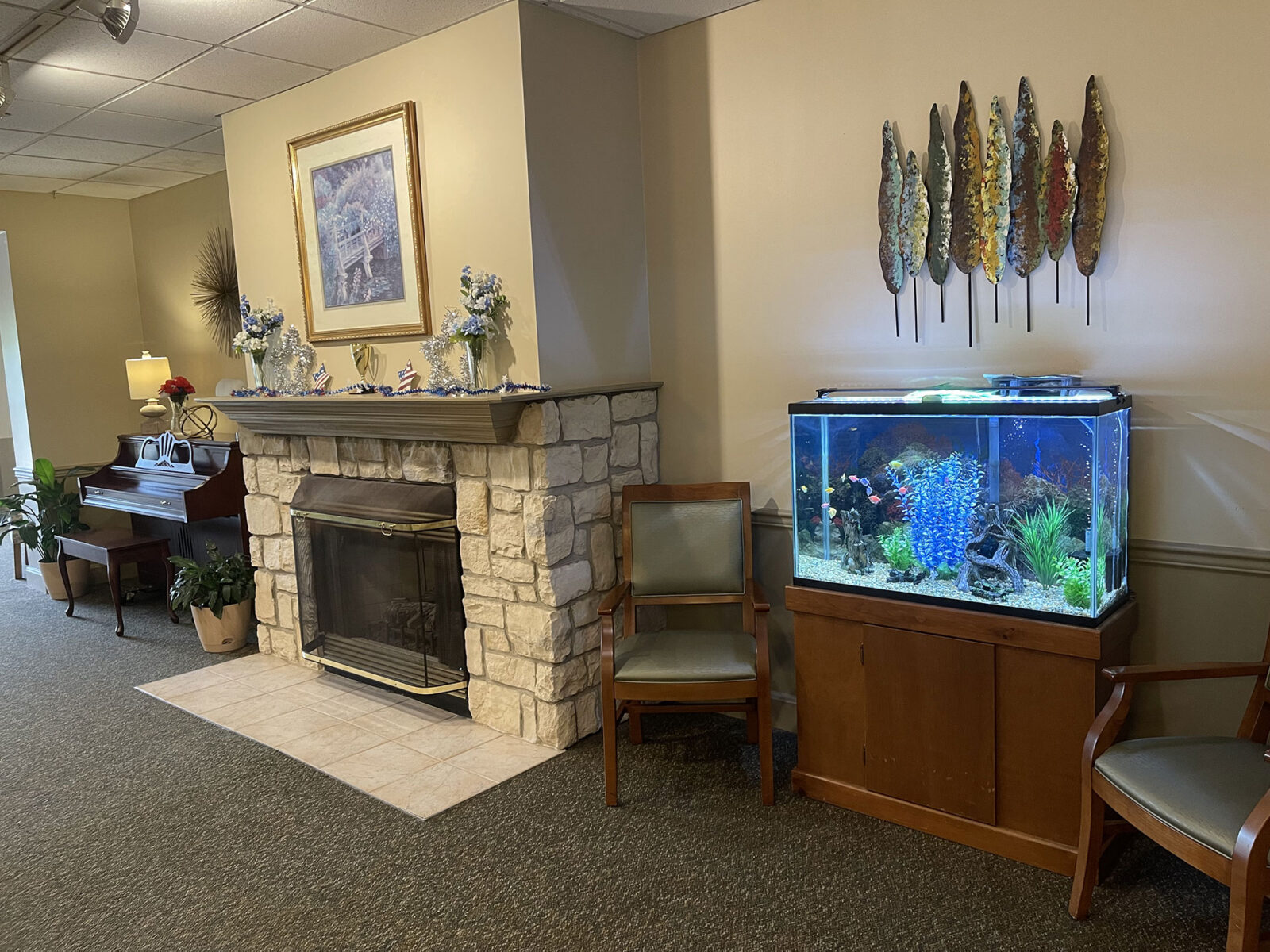 Living room with aquarium, fireplace, and piano.