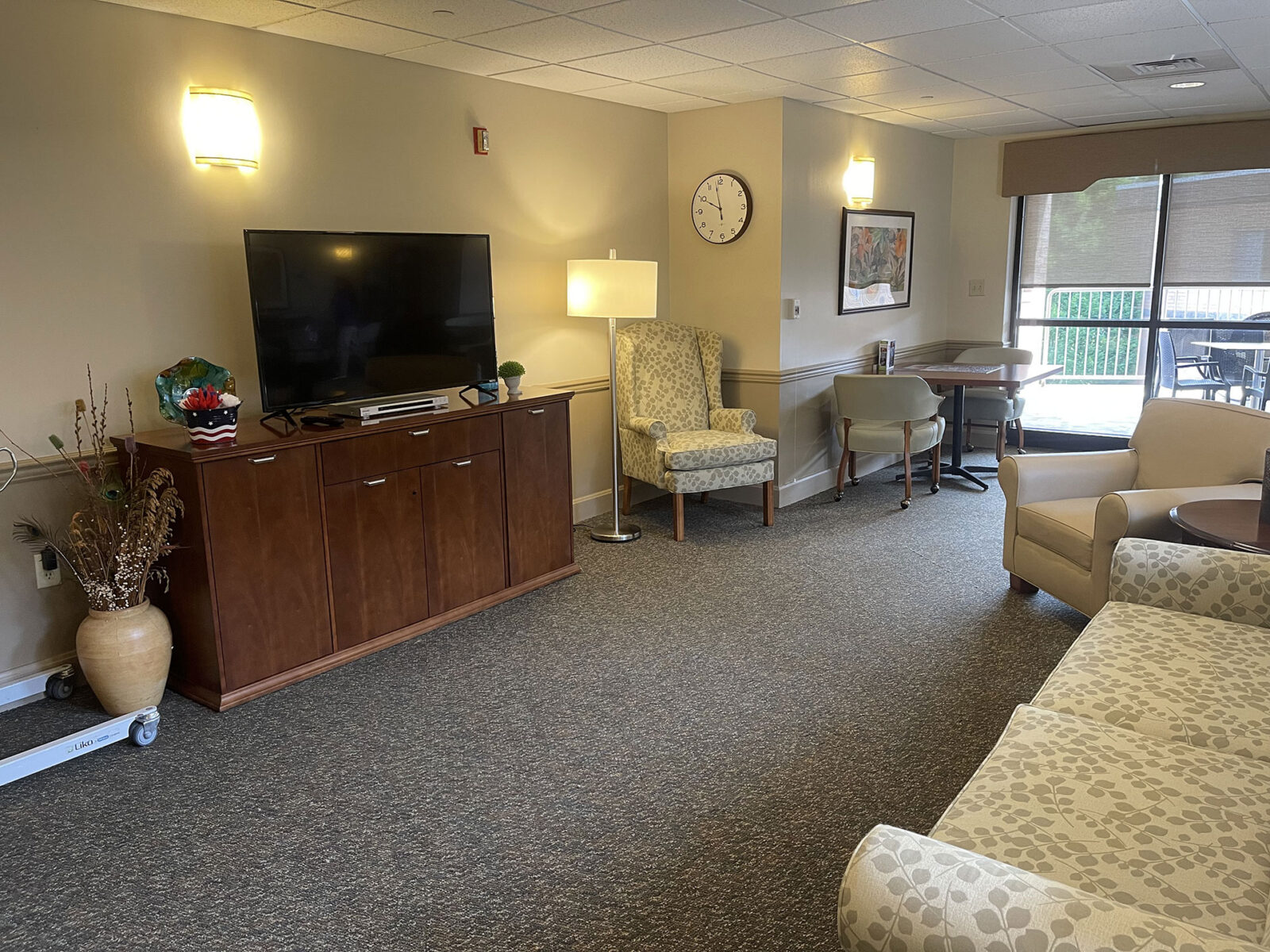 Cozy lounge area with seating, TV, and natural light.