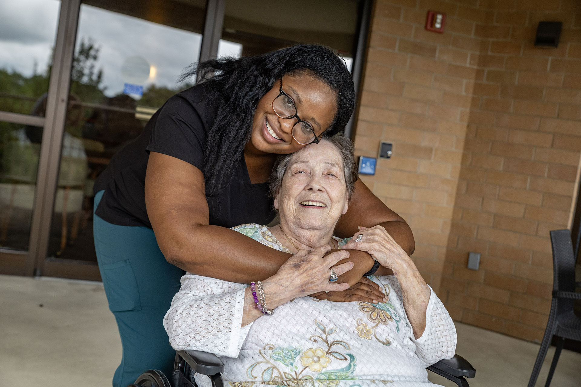 Two women sharing a joyful moment outdoors, smiling together.