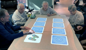 Concordia at Villa St. Joseph residents play a matching game on their own Tovertafel tabletop projector.
