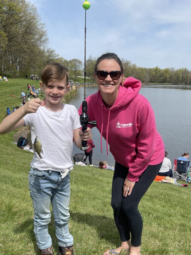 Concordia volunteer with kid who caught a fish
