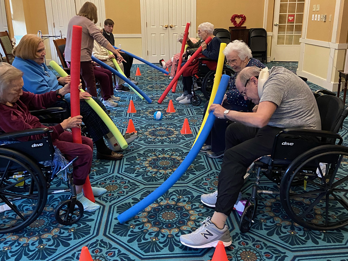 Residents play hockey with pool noodles