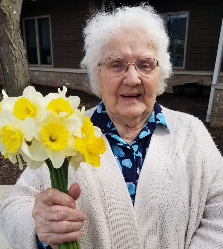 Concordia resident Anne holding up daffodils