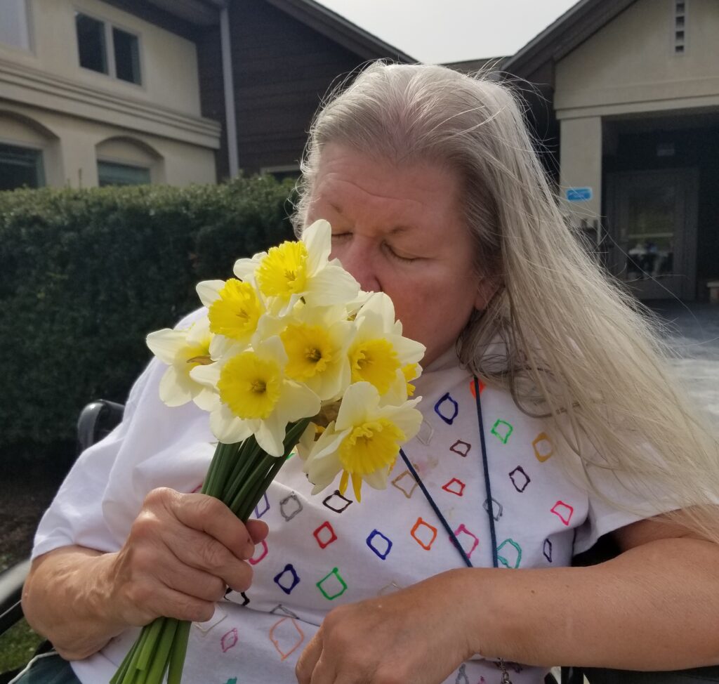 Concordia resident Linda smelling a bouquet of daffodils