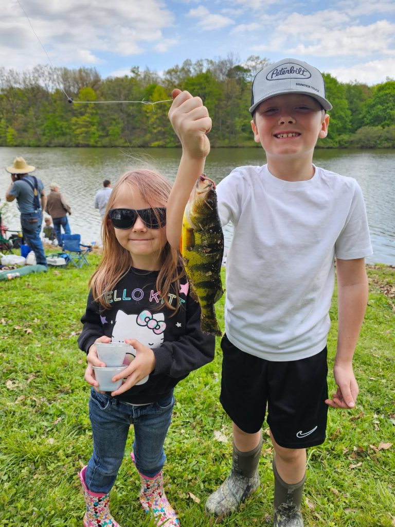 Two little kids holding up a fish at the Concordia Fishing Derby