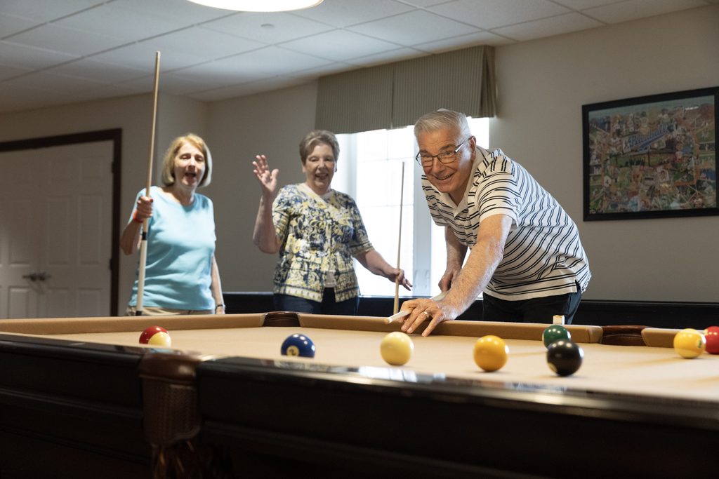 Highpointe at Rebecca retirement living residents playing pool together